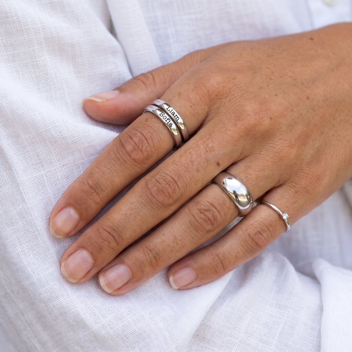 Anillo fino apilable con nombre – plata – combinado con otros anillos, puesto, primer plano